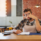 Business owner reviewing invoices and contract terms to enforce payment terms legally