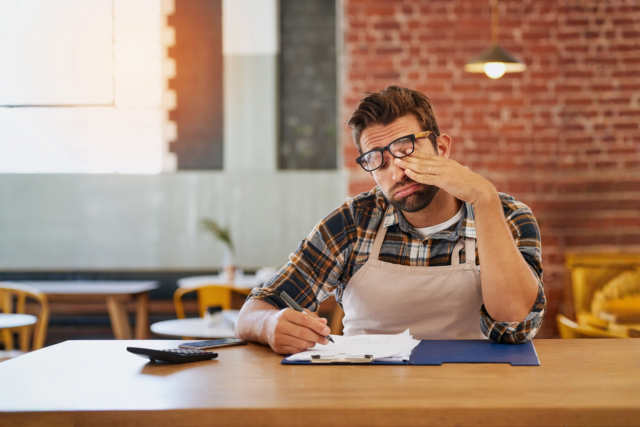 Business owner reviewing invoices and contract terms to enforce payment terms legally